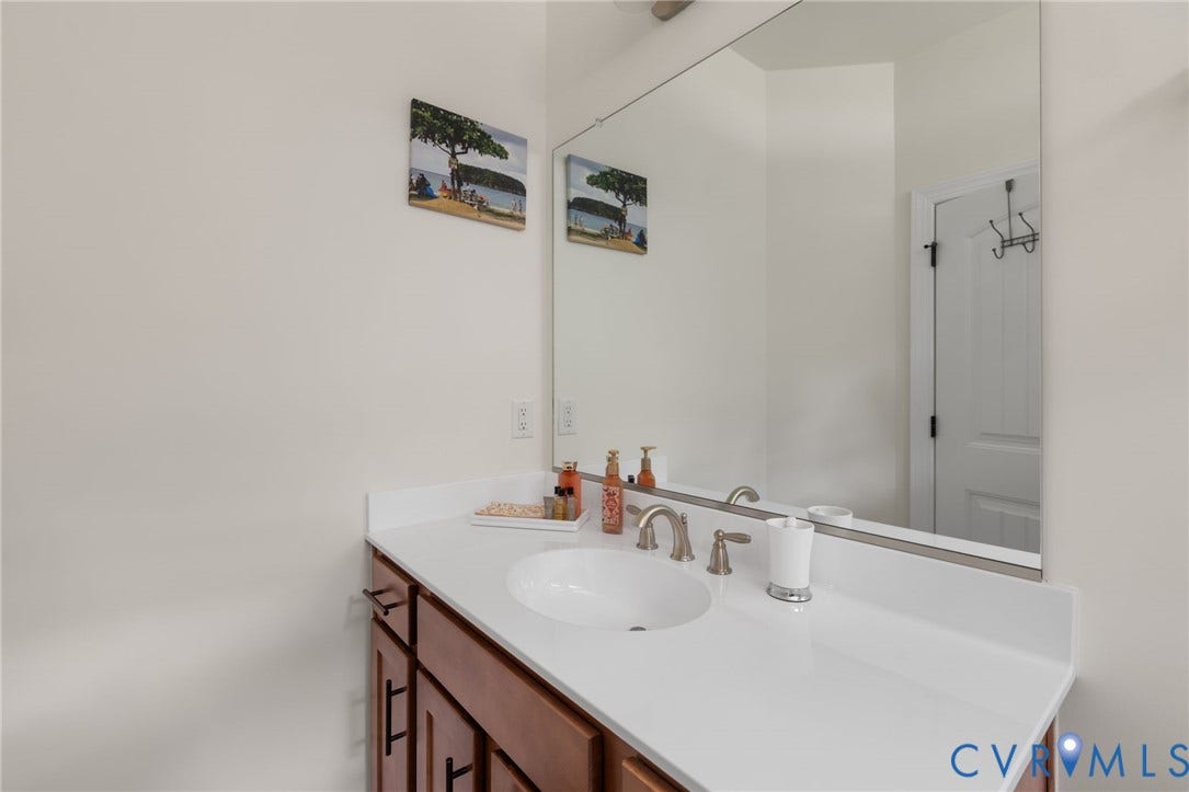 Built-in vanity with a white countertop, undermount sink, and brushed nickel faucet