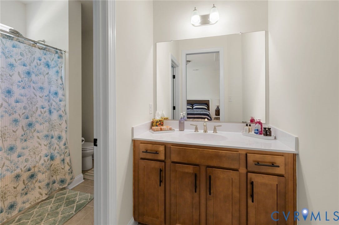 Bathroom vanity with a white countertop and wood-finish cabinetry