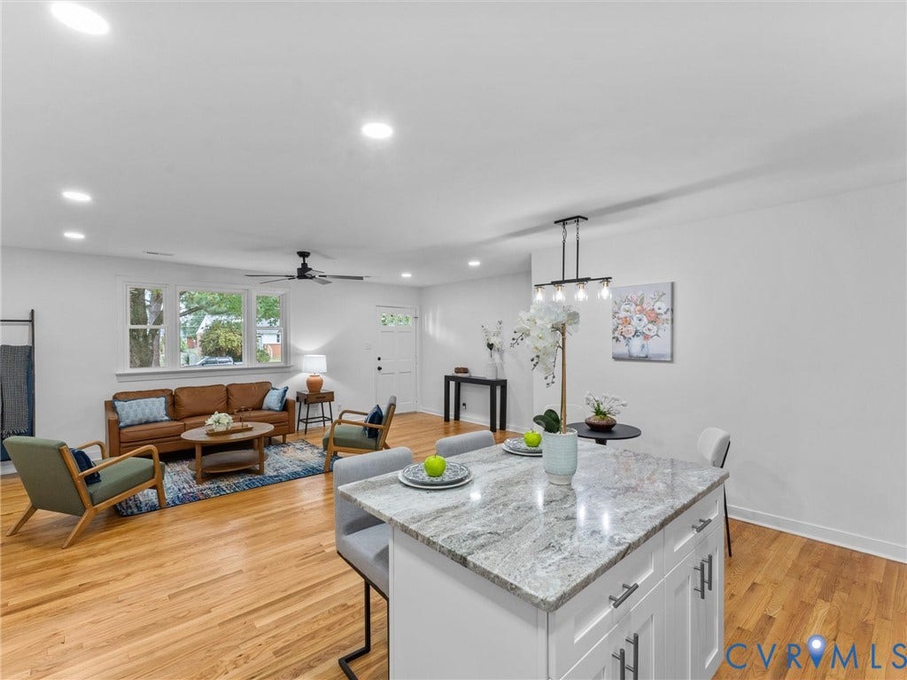 3626 Reynolds Road, Richmond, VA 23223 Open-concept living area featuring hardwood flooring, recessed lighting, and a white kitchen island with a stone countertop and seating