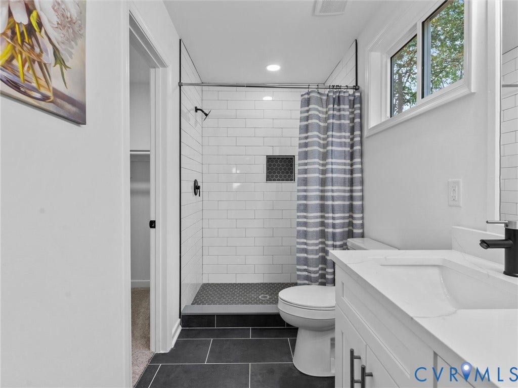3626 Reynolds Road, Richmond, VA 23223 White subway tile shower with a dark tile base and accent niche