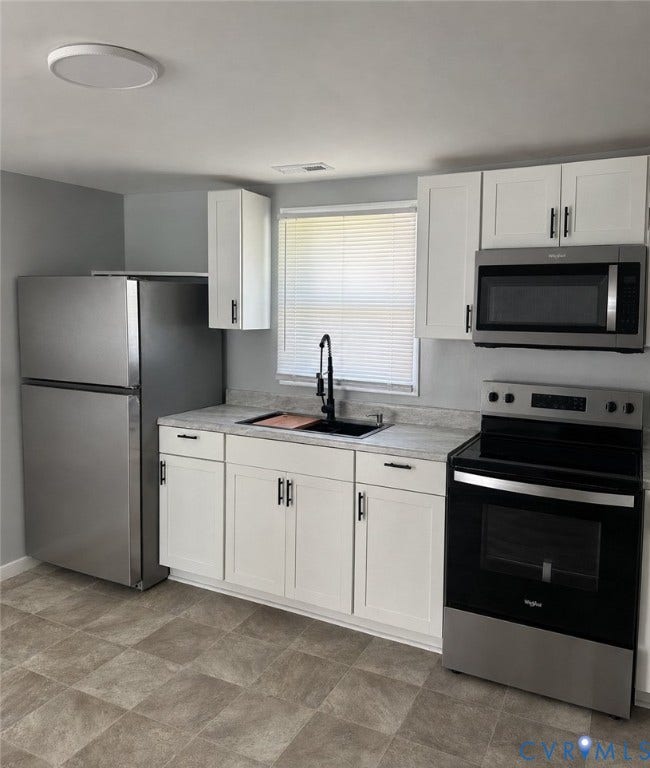 4307 3rd Street, Richmond, VA 23223 Modern kitchen featuring white shaker cabinetry, stainless steel appliances, a black gooseneck faucet, and light-toned countertops