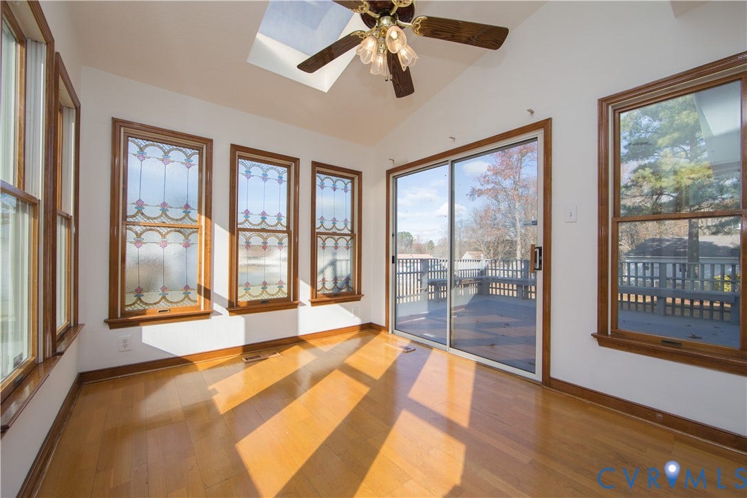 19224 Maurer Lane, Colonial Heights, VA 23834 Vaulted ceiling with skylight, wood-finish flooring, sliding glass door to exterior deck, stained-glass windows, and a ceiling fan with integrated lighting