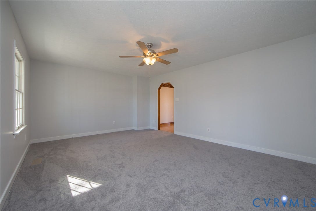 19224 Maurer Lane, Colonial Heights, VA 23834 Carpeted room with a ceiling fan, an arched doorway, and a window