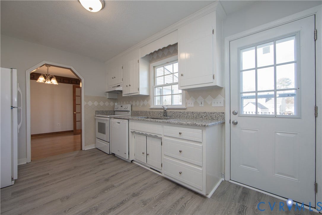 19224 Maurer Lane, Colonial Heights, VA 23834 Kitchen featuring white cabinetry, gray wood-finish flooring, a window above the sink, a white appliance suite, and an arched doorway