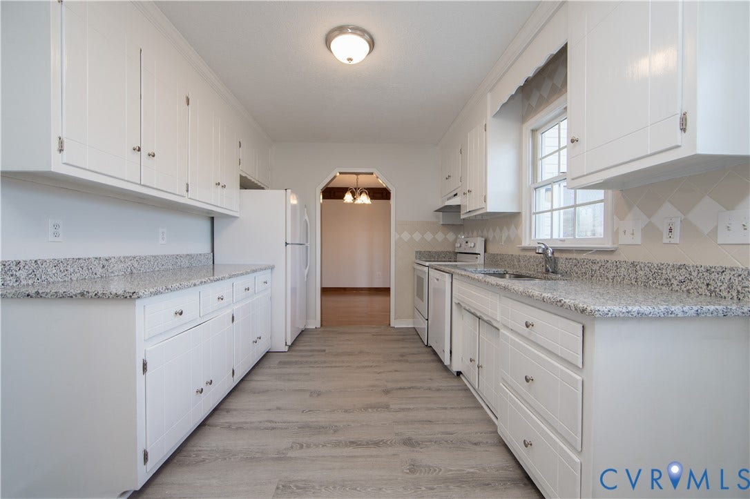 19224 Maurer Lane, Colonial Heights, VA 23834 White cabinetry with silver hardware, speckled countertops, window over the sink, and wood-finish flooring