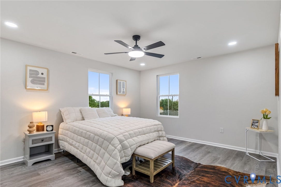 Recessed lighting, wood-finish flooring, two large windows, ceiling fan with integrated lighting, and light gray wall paint