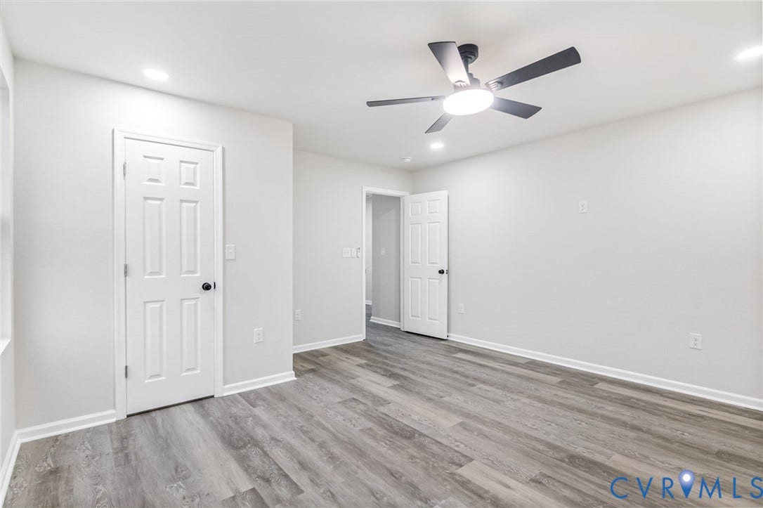 Spacious room with wood-finish flooring, recessed lighting, and a contemporary ceiling fan