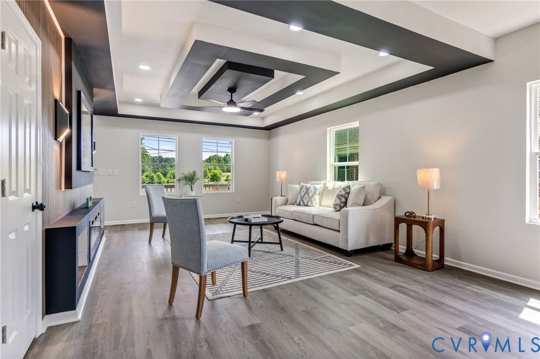 Tray ceiling with recessed lighting and a ceiling fan, wood-finish flooring, and multiple windows