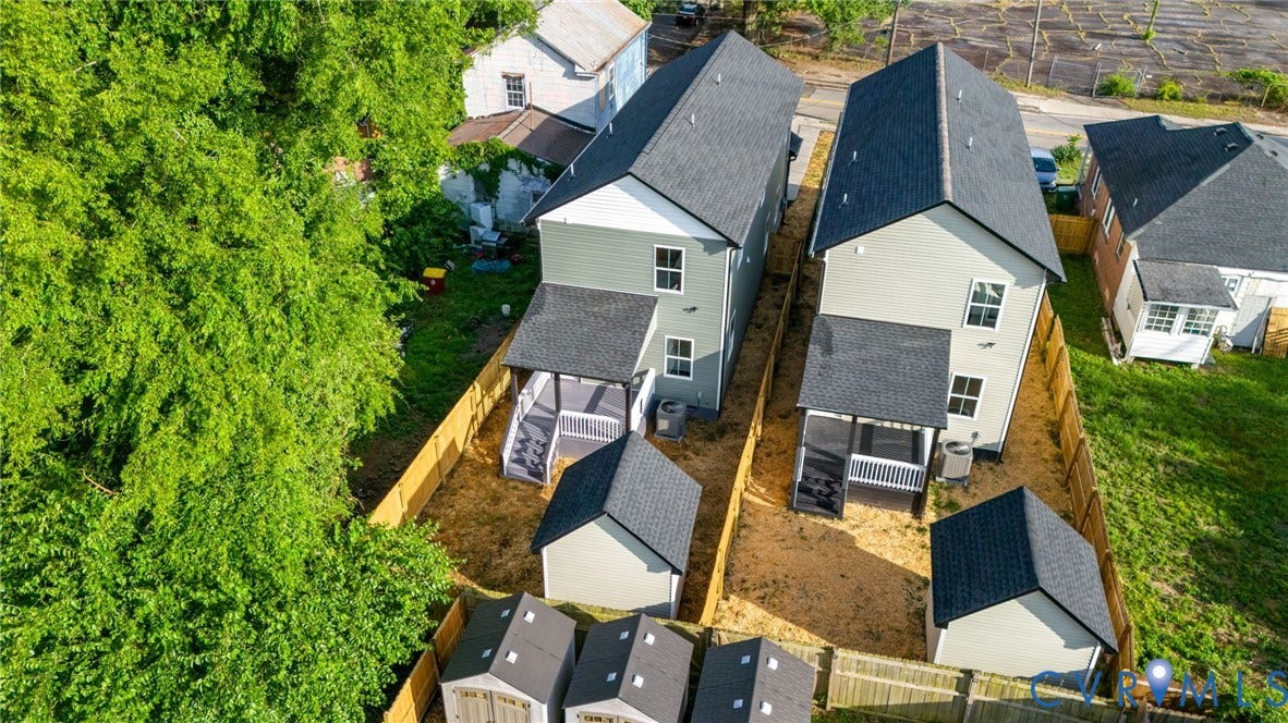 Two properties featuring light-colored siding, dark shingle roofs, and fenced yards