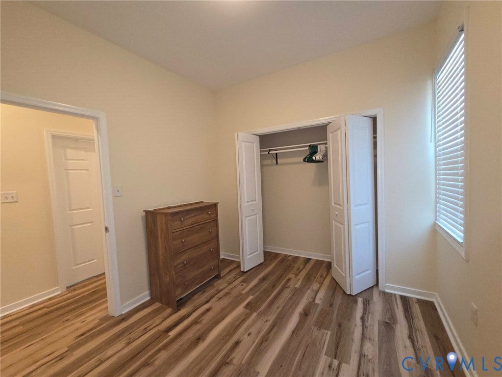 3400 Decatur Street, Richmond, VA 23224 Wood-finish flooring, bi-fold closet doors, window with blinds, and light-toned walls