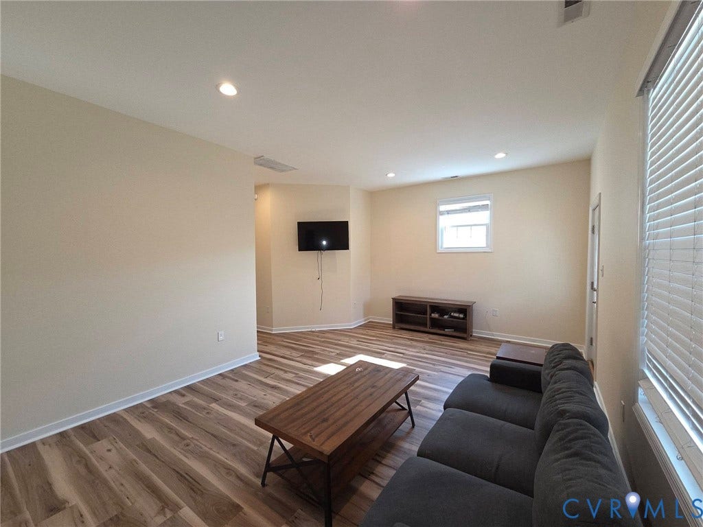3400 Decatur Street, Richmond, VA 23224 Spacious living area featuring wood-finish flooring, recessed lighting, and a white window with blinds