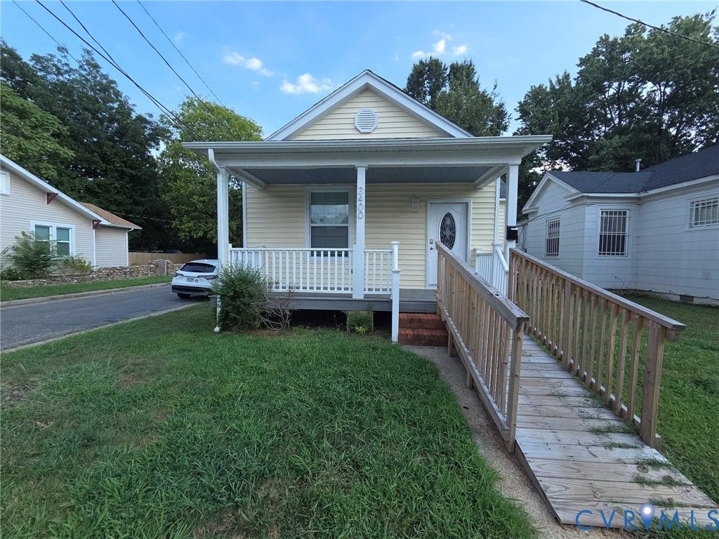 3400 Decatur Street, Richmond, VA 23224 Yellow siding exterior with a covered front porch, white railing, white front door, and a wooden access ramp