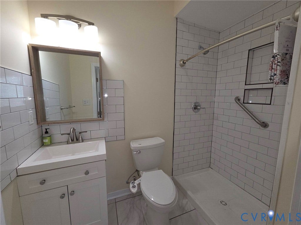 3400 Decatur Street, Richmond, VA 23224 White subway tile shower enclosure with built-in niches and an integrated grab bar