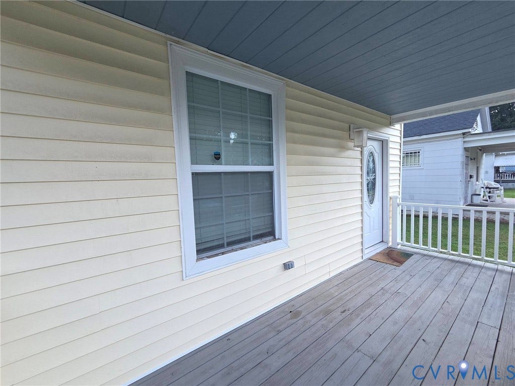 3400 Decatur Street, Richmond, VA 23224 Wood-finish porch decking, white railing, and a white entry door with an oval glass insert