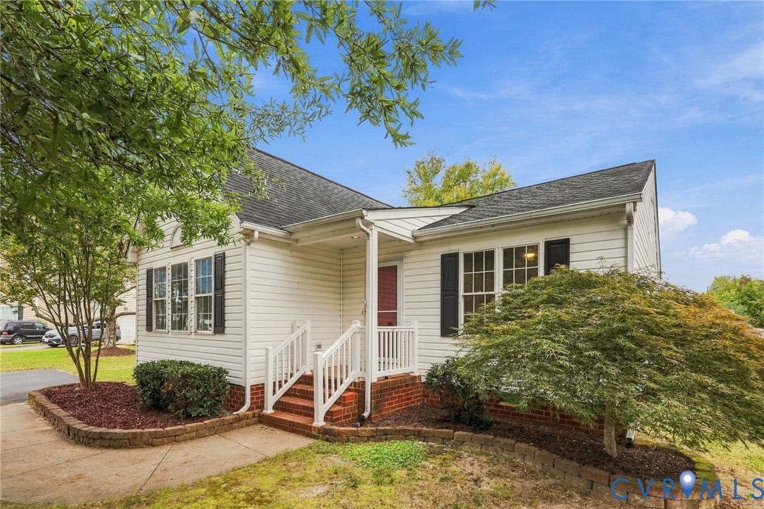 White siding exterior featuring a covered front porch with white railings, a brick foundation, and black louvered shutters