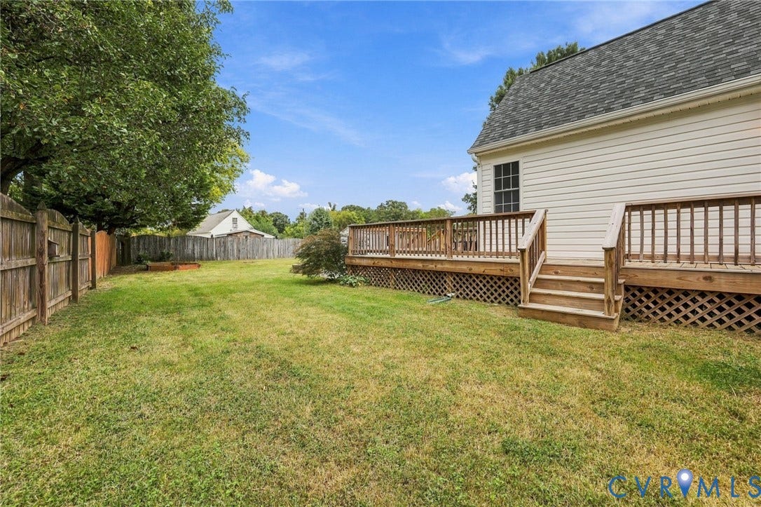 Expansive backyard featuring a wood privacy fence, a large wood deck with railings, and a multi-level deck design