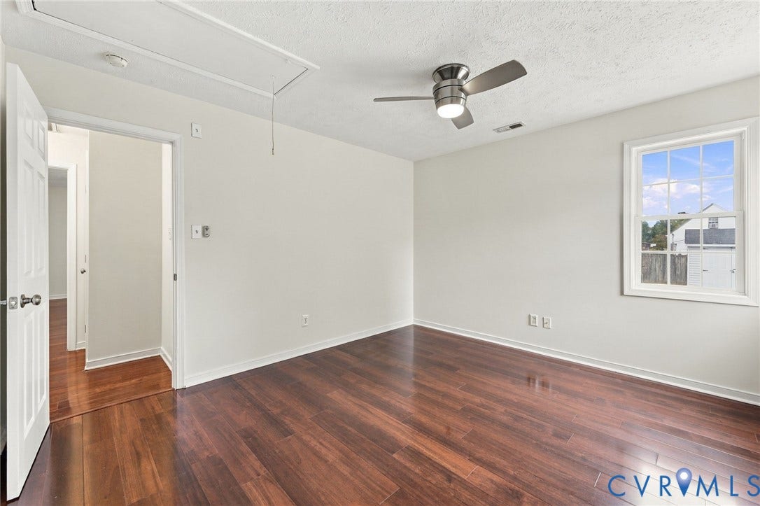 Wood-finish flooring, white trim, a double-paned window, and a ceiling fan with integrated lighting