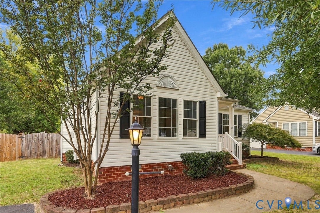 Traditional exterior with horizontal siding, a gabled roofline, and brick foundation