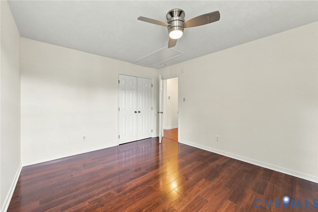 Wood-finish flooring, white walls, and a ceiling fan with integrated lighting