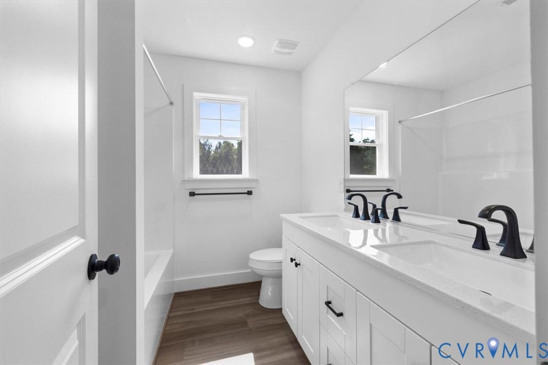 2242 Lakeview Drive, Powhatan, VA 23139 Dual vanity with white shaker-style cabinetry, matte black hardware, and integrated sinks