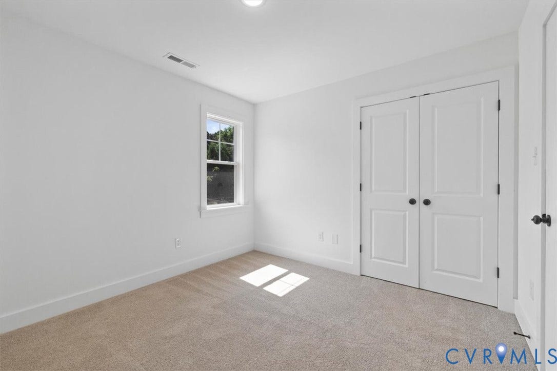 2242 Lakeview Drive, Powhatan, VA 23139 Neutral wall palette, window with exterior scenery, carpeted flooring, and white double-panel doors with dark hardware