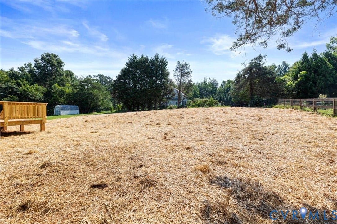 2242 Lakeview Drive, Powhatan, VA 23139 Expansive land area featuring a wooden deck, mature trees, and partial fencing