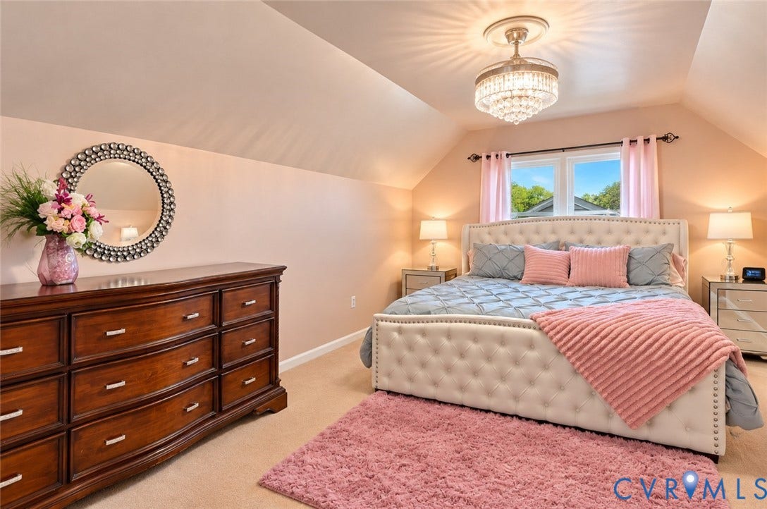 Recessed window with exterior views, vaulted ceiling, and a prominent crystal chandelier