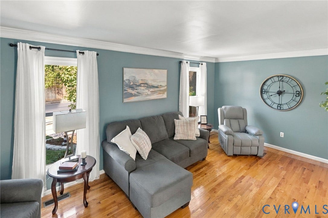 Hardwood flooring throughout, crown molding, and abundant natural light from multiple windows
