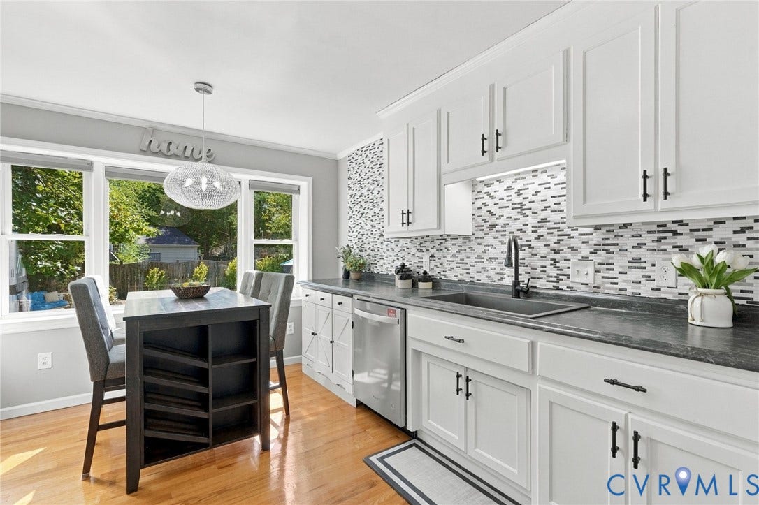 Kitchen featuring white cabinetry with dark hardware, a tile backsplash, stainless steel dishwasher, and a farmhouse sink with a gooseneck faucet