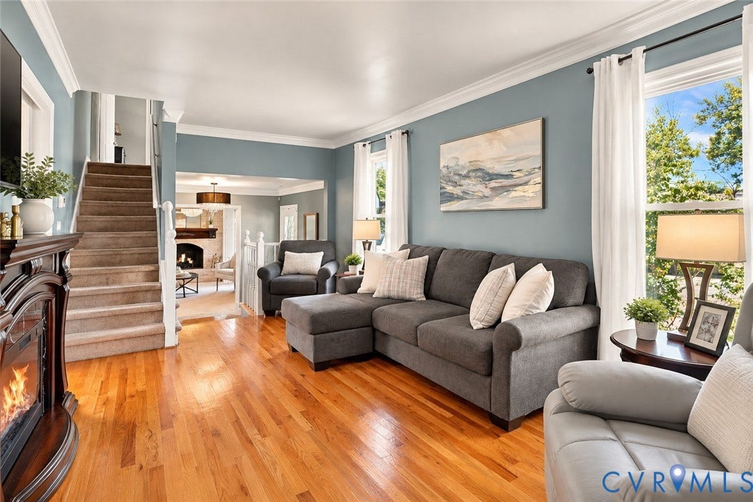 Hardwood flooring, crown molding, white trim, staircase, an electric fireplace