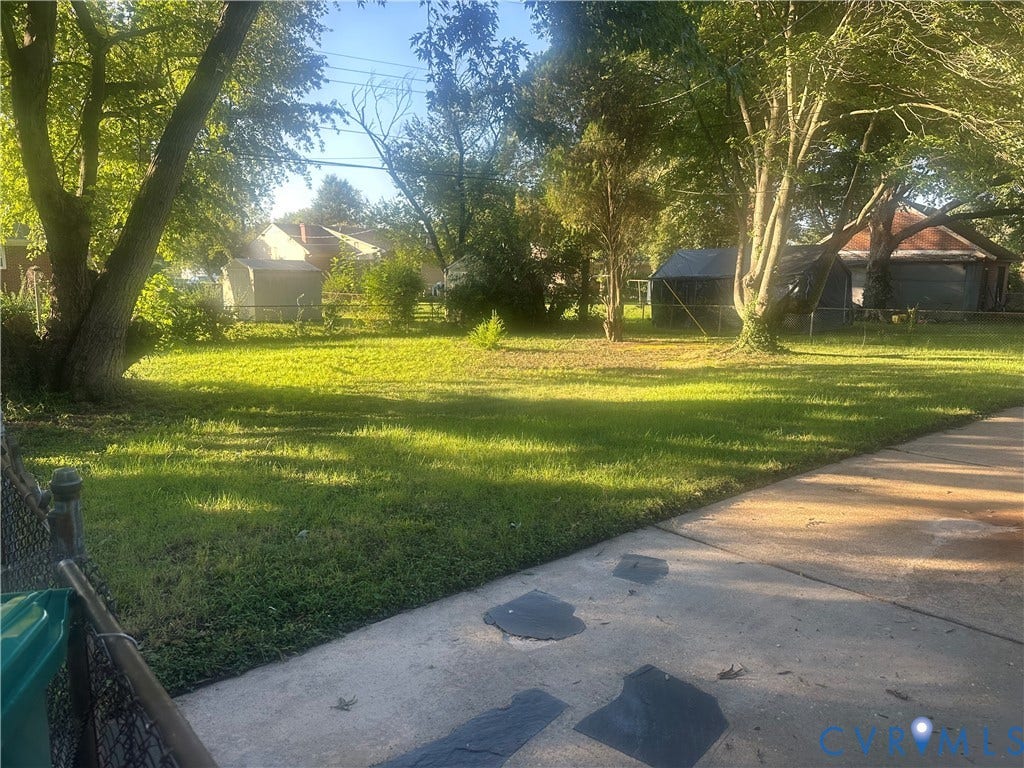 Expansive green lawn with mature trees and a concrete walkway