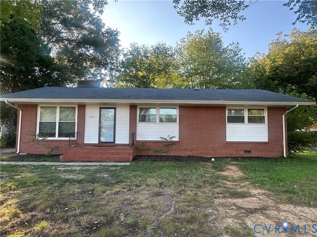 Brick exterior with white siding accents and dark shingle roofing