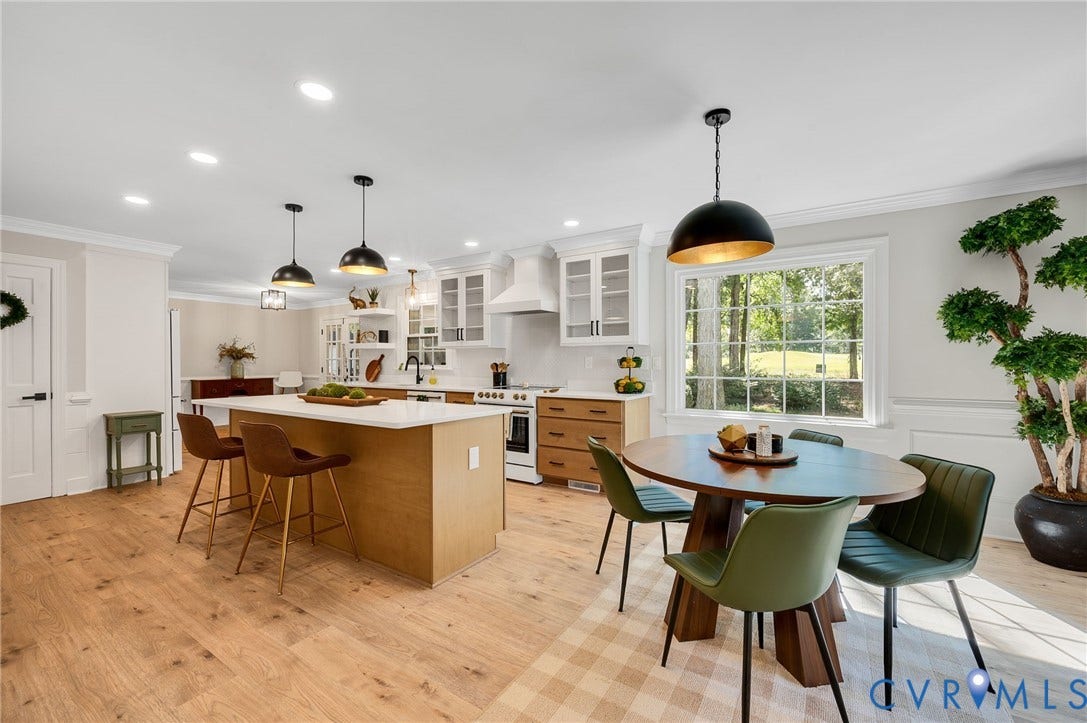 13800 W Salisbury Road, Salisbury, Midlothian, VA 23113 Bright kitchen with wood-finish flooring, a central island with countertop seating, white cabinetry, a built-in range hood, and a large window