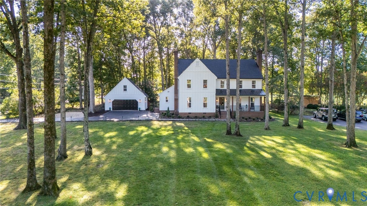 13800 W Salisbury Road, Salisbury, Midlothian, VA 23113 Two-story residence with a covered front porch, a two-car detached garage, a paved driveway, and established trees