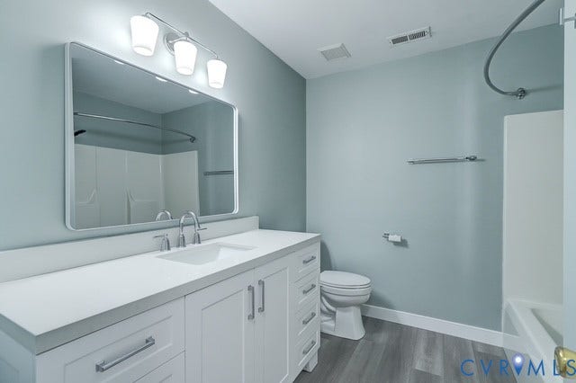 8113 Ainsdale Lane, Chesterfield, VA 23832 White vanity with integrated sink, contemporary polished chrome faucet, rectangular framed mirror, and wood-finish flooring
