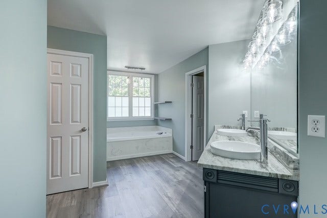 8113 Ainsdale Lane, Chesterfield, VA 23832 Dual vanity with oval vessel sinks, a large mirror, and a contemporary lighting fixture