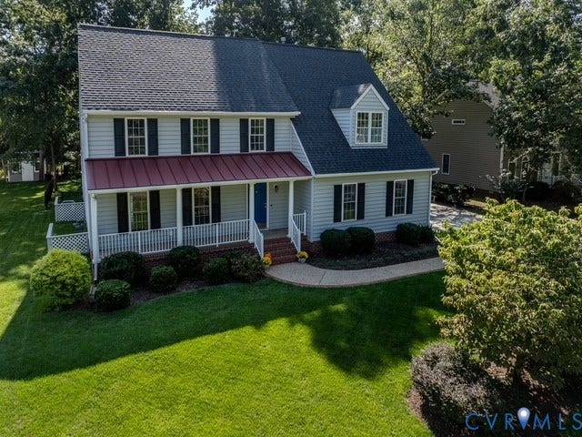 8113 Ainsdale Lane, Chesterfield, VA 23832 Two-story Colonial home featuring light-colored siding, a dark shingled roof, and a red metal-roofed front porch
