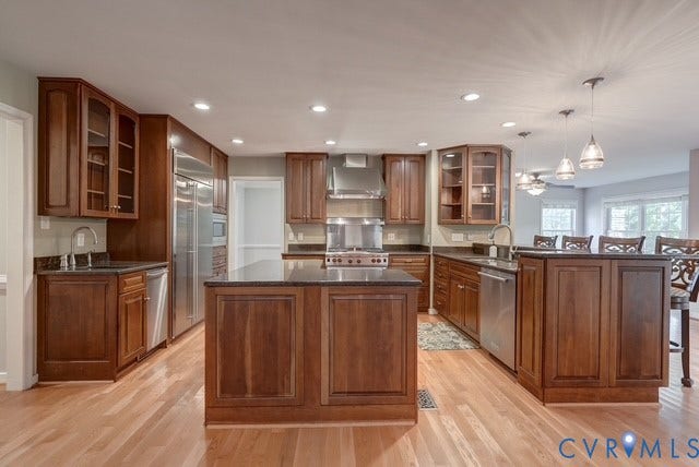 8113 Ainsdale Lane, Chesterfield, VA 23832 Kitchen featuring hardwood flooring, dark wood cabinetry, stainless steel appliances, recessed lighting, and a central island with countertop
