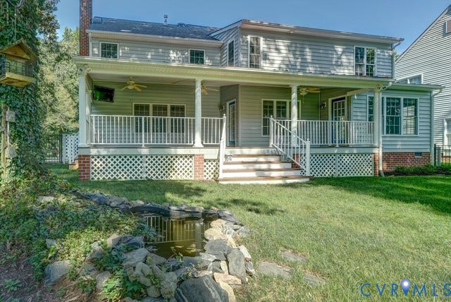 8113 Ainsdale Lane, Chesterfield, VA 23832 Rear exterior featuring a covered porch with ceiling fans, white railing, and lattice skirting