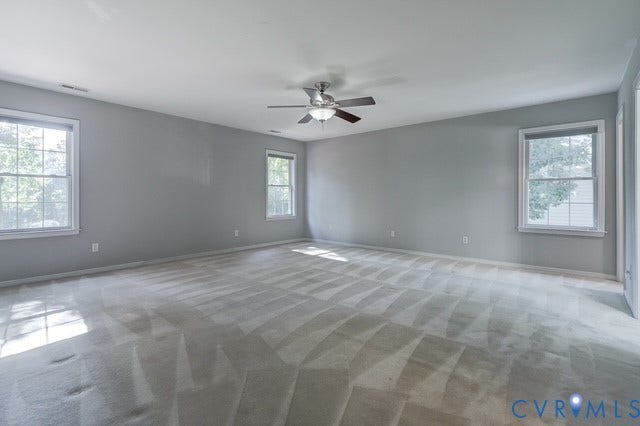 8113 Ainsdale Lane, Chesterfield, VA 23832 Expansive room featuring light gray wall paint, light-toned carpeting, multiple windows, and a ceiling fan with integrated lighting