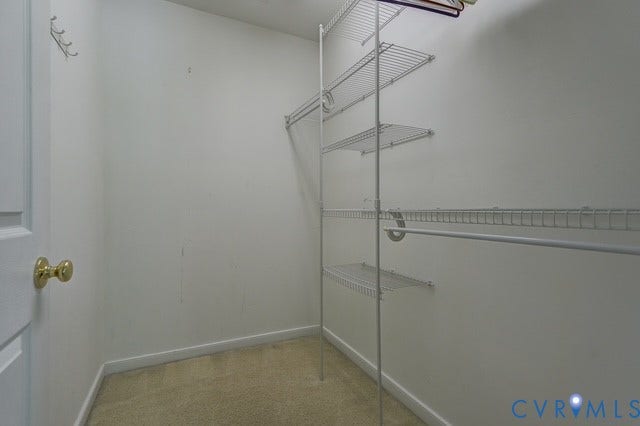 8113 Ainsdale Lane, Chesterfield, VA 23832 Walk-in closet with wire shelving system and hanging rods, featuring a brass-toned doorknob