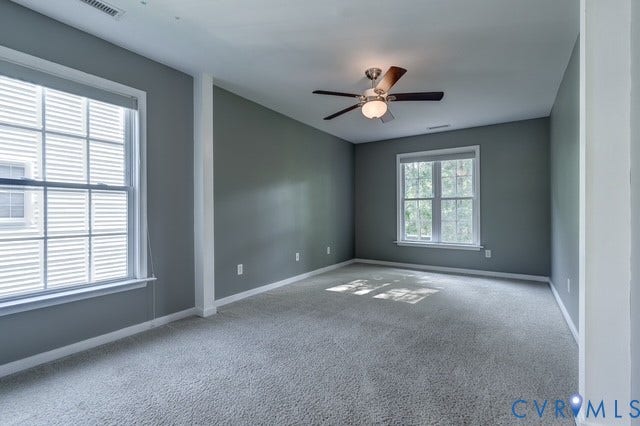 8113 Ainsdale Lane, Chesterfield, VA 23832 Spacious room featuring neutral wall tones, plush carpeting, multiple windows, a ceiling fan, and white trim accents