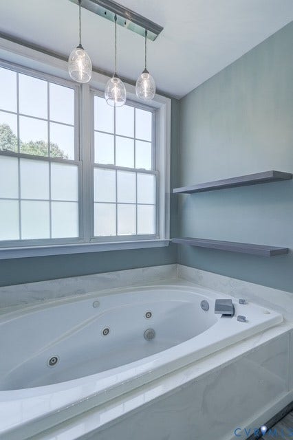 8113 Ainsdale Lane, Chesterfield, VA 23832 Soaking tub with integrated jets, white window frames, modern pendant light fixture, two floating shelves, and a white countertop surround