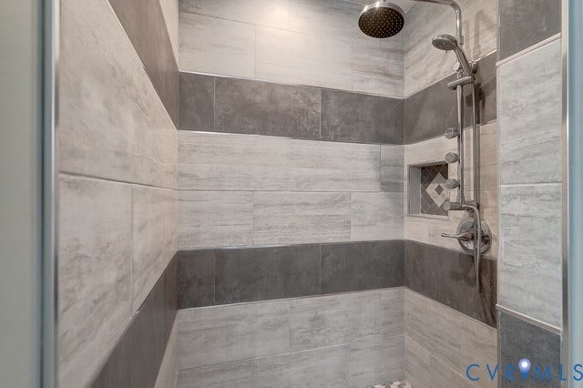 8113 Ainsdale Lane, Chesterfield, VA 23832 Tiled shower stall featuring a rainfall showerhead, handheld shower, built-in niche with mosaic tile, and chrome fixtures