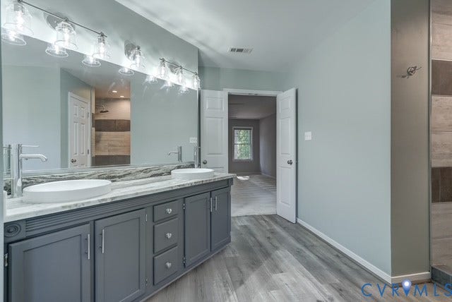8113 Ainsdale Lane, Chesterfield, VA 23832 Double vanity with vessel sinks, polished chrome faucets, a full-width mirror, and overhead linear lighting