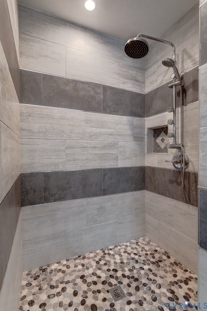 8113 Ainsdale Lane, Chesterfield, VA 23832 Shower enclosure with striped tile walls, pebble-finish flooring, recessed lighting, rainfall showerhead, and a built-in niche with decorative tile