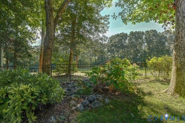 8113 Ainsdale Lane, Chesterfield, VA 23832 Expansive exterior featuring mature trees, a manicured lawn, and a black metal fence