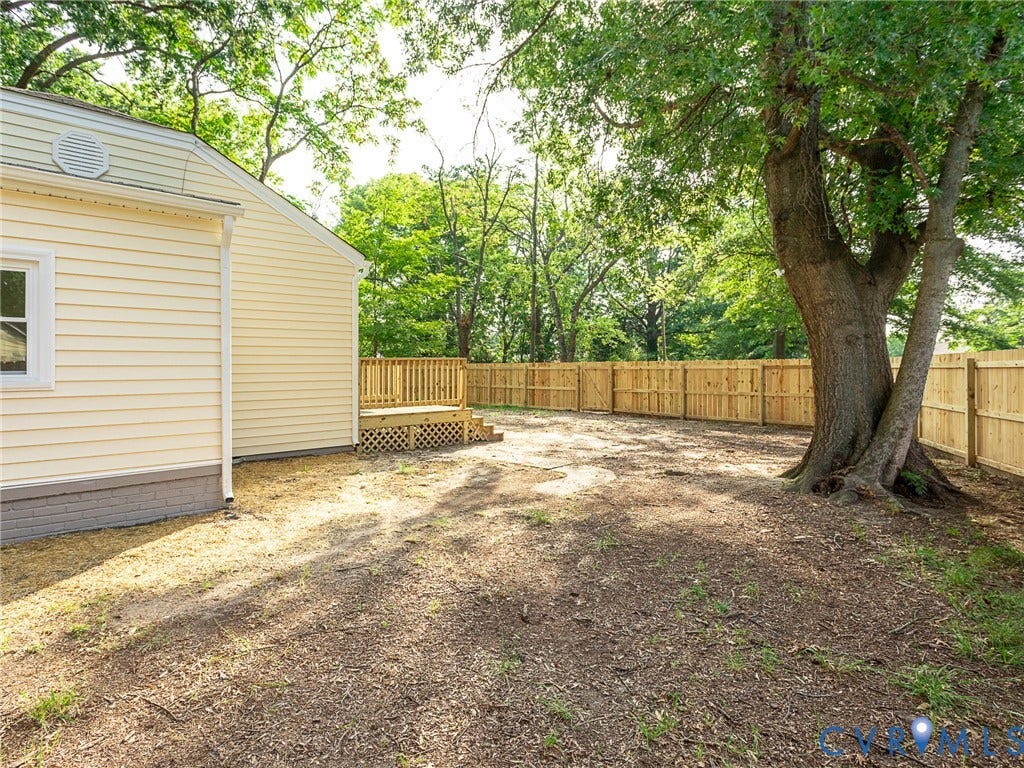 1601 N 25th Street, Richmond, VA 23223 Wood privacy fence enclosing the backyard with a large mature tree and a wood deck