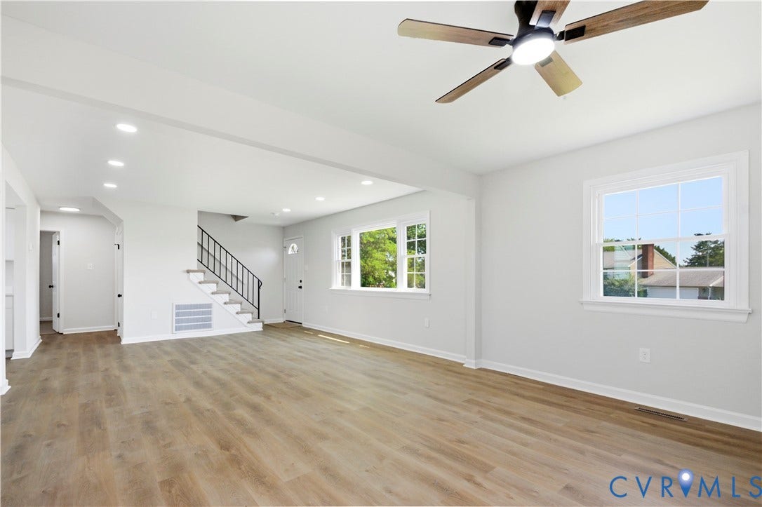 Open-concept living space featuring wood-finish flooring, recessed lighting, and a ceiling fan