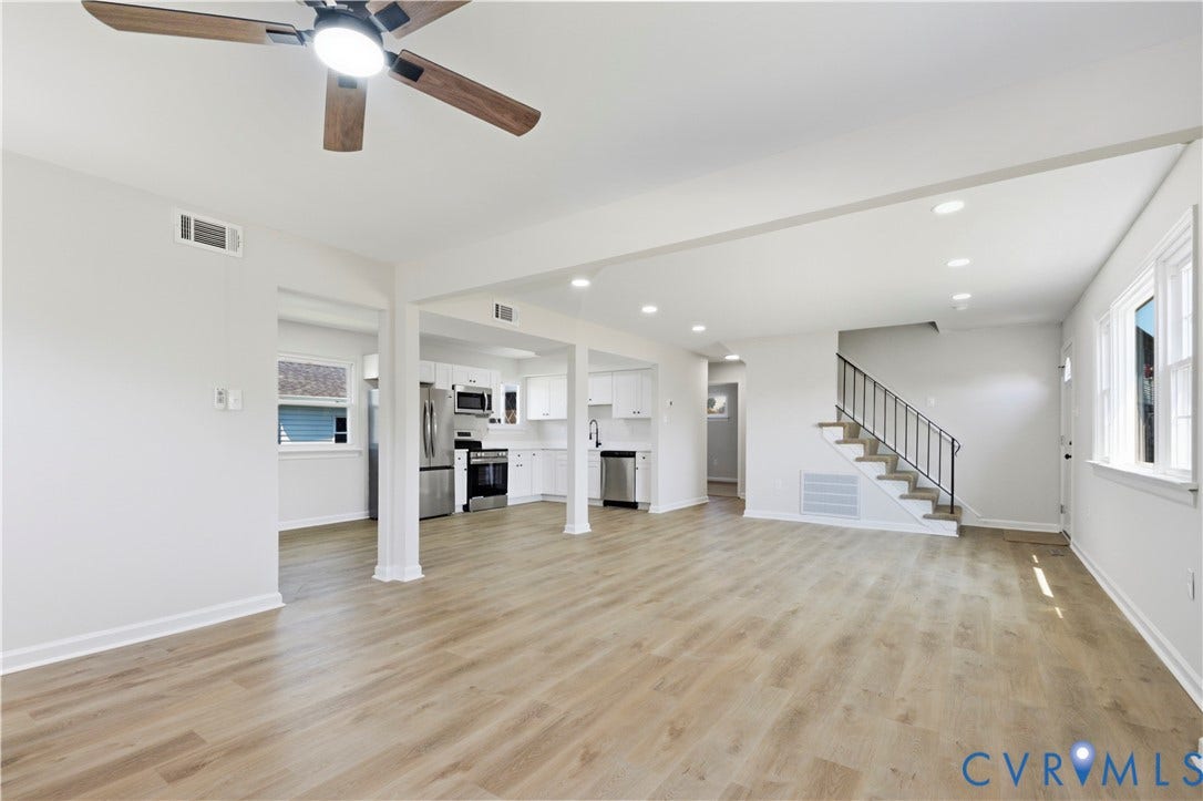 Wood-finish flooring throughout, recessed lighting, white cabinetry, stainless steel appliances, and a ceiling fan with integrated lighting